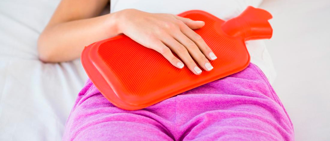 Грелка на животе у женщины